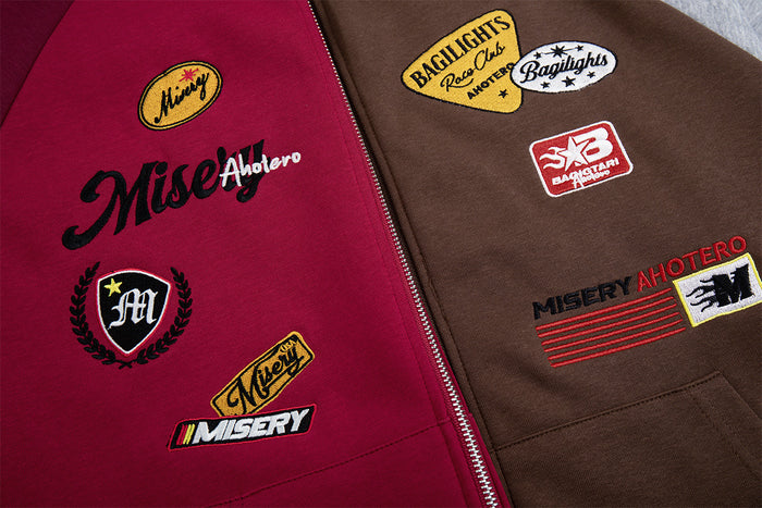 Close-up of racing-style patches on burgundy and brown hoodie panels beside the front zipper