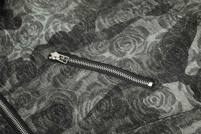 Detailed view of a silver zip pocket on the jacket's gray and black rose-pattern camouflage fabric