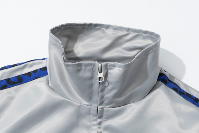 Close-up of the white satin bomber jacket's stand collar and metal front zipper