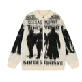 Front view of the cream knit zip-up cardigan with black shadow figures, text, and ribbed trim