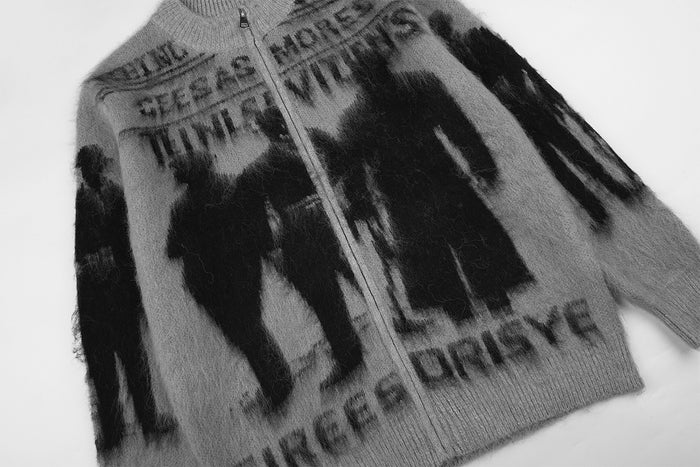 Angled view of the gray zip-up cardigan showing its full front, shadow figures, text, and sleeves
