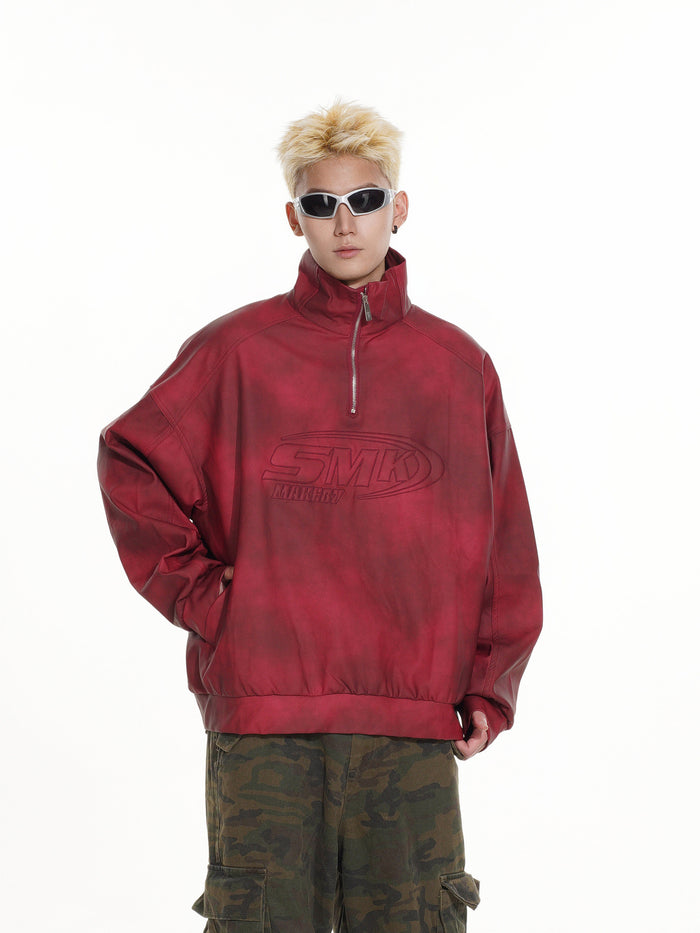 Front three-quarter view of a red half-zip pullover with stand collar and chest graphic