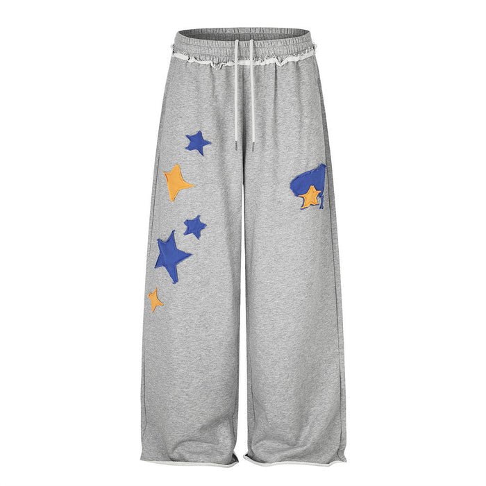 Men's heather gray wide-leg sweatpants with blue and orange star appliqués and frayed drawstring waistband