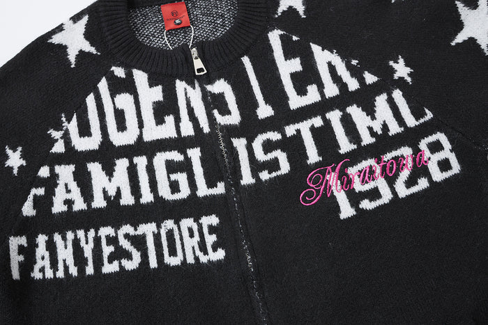 Close-up of the black cardigan front showing large white letter print, stars, and pink script detail