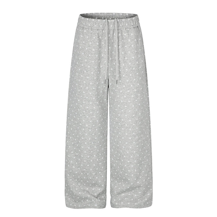 Men's wide-leg sweatpants with all-over star print in heather grey and black, showing relaxed straight-leg silhouette and dra