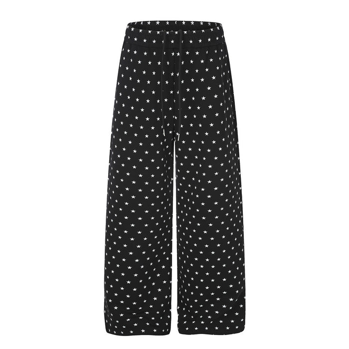 Black wide-leg sweatpants covered in small white star prints, shown from the front