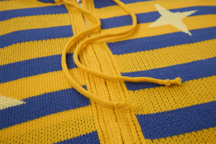 Close-up of mustard yellow and blue knit stripes with a matching hood drawstring and cream star motif