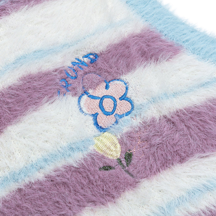 Close-up of a colorful embroidered flower detail on the fuzzy lavender and blue striped knit