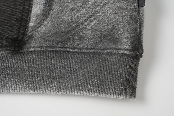 Close-up of the hoodie’s gray ribbed bottom hem joined to the acid-washed body fabric