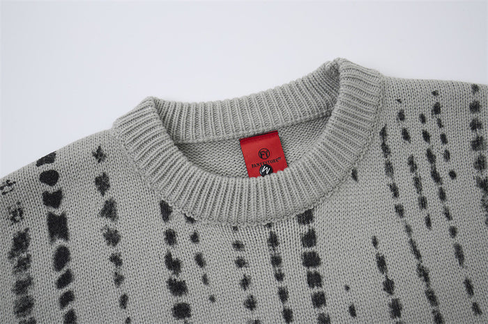 Close-up of the gray sweater's ribbed crew neckline, knit texture, and red neck label