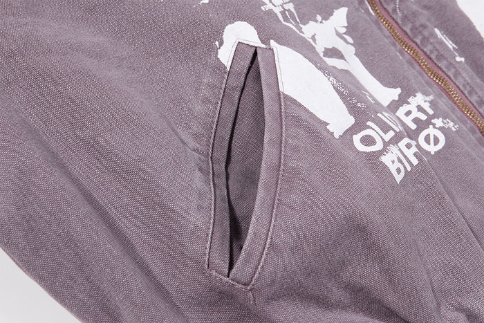 Close-up of an angled welt pocket on the purple-gray canvas bomber jacket front