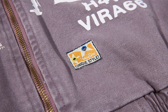Close-up of a small colorful rectangular patch beside the zipper on the purple-gray jacket front