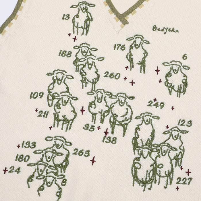 Close-up of the cream vest front featuring multiple green sheep graphics, numbers, and small red crosses
