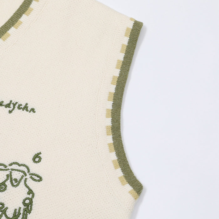 Close-up of the cream knit vest armhole with olive edging and alternating cream and yellow trim