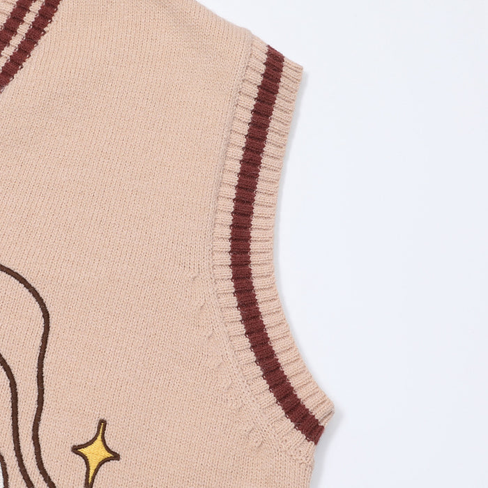 Close-up of the pink sweater vest armhole with burgundy and cream striped knitted edging