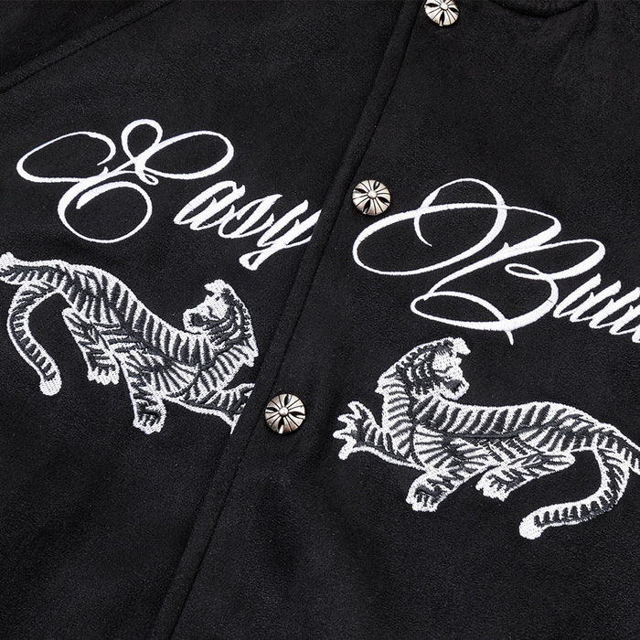 Close-up of white script lettering and embroidered tiger motifs across the black bomber jacket chest