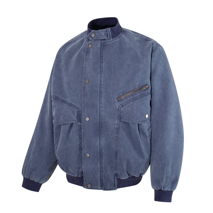 Front view of a washed blue canvas bomber jacket with stand collar, snap closure, zip pocket and two flap pockets