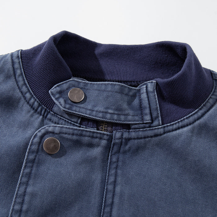 Close-up of the washed blue bomber jacket's ribbed stand collar, snap-tab closure and front fastening