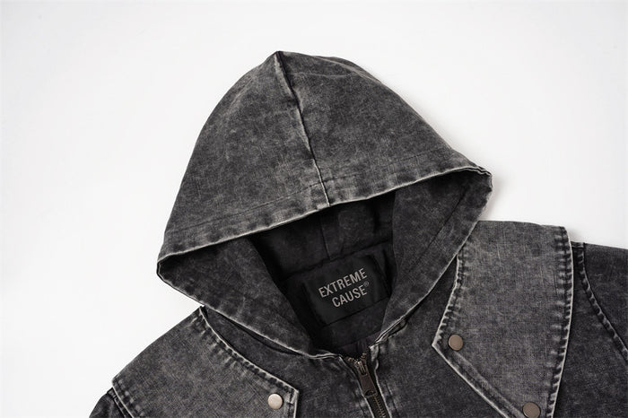 Close-up of the charcoal jacket hood showing washed canvas texture, lining, and sewn neck label