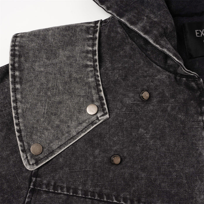 Close-up of a charcoal jacket flap detail with contrast stitching and three round snap fasteners