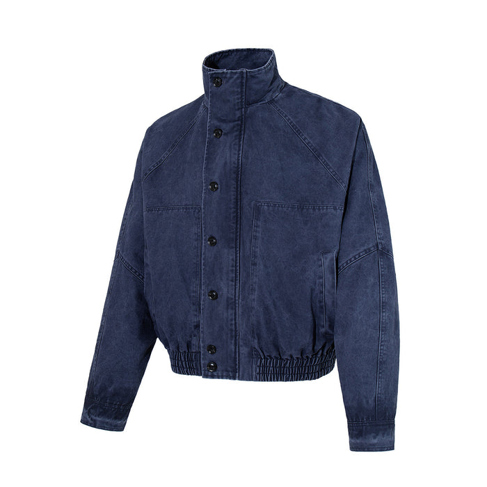 Washed navy bomber jacket front with stand collar, button closure, chest pockets, raglan sleeves, and elastic hem