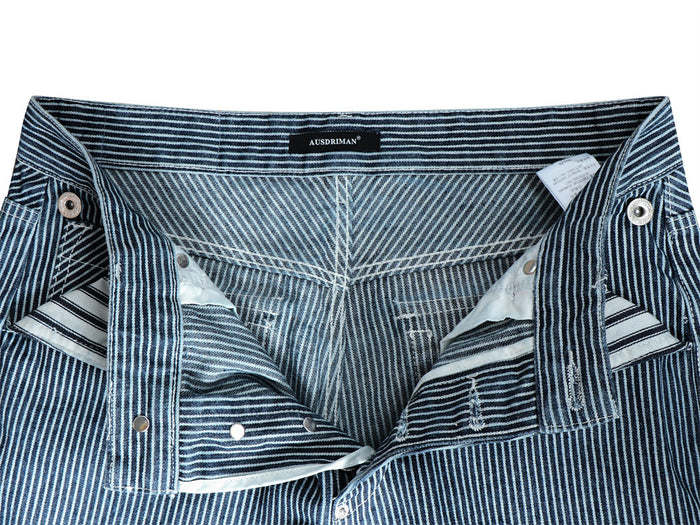 Open waistband and fly of striped denim jeans showing the inner seams, buttons, and striped pocket lining