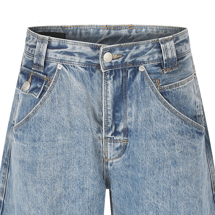 Close-up of the front waistband on light blue washed jeans with belt loops, button closure, and curved pockets