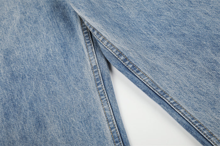 Close-up of light blue denim showing the inner leg seam and contrasting double stitching