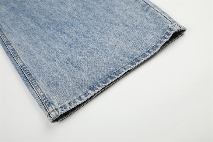 Close-up of a light blue denim jeans hem showing folded edge and contrasting stitched seam