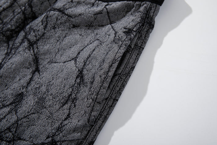 Close-up of the gray crackle-print fabric and stitched side edge on the jeans leg