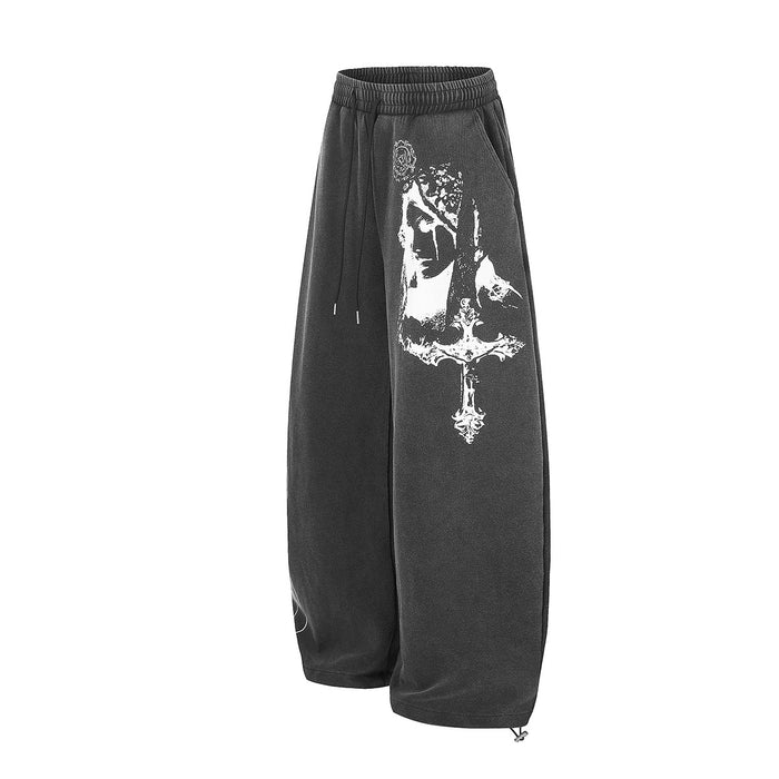 Black wide-leg sweatpants shown at an angle with a large white gothic portrait print