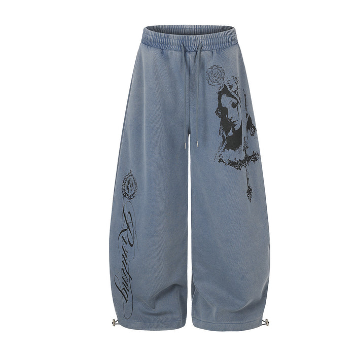 Washed blue wide-leg sweatpants with black gothic portrait and script prints on the front