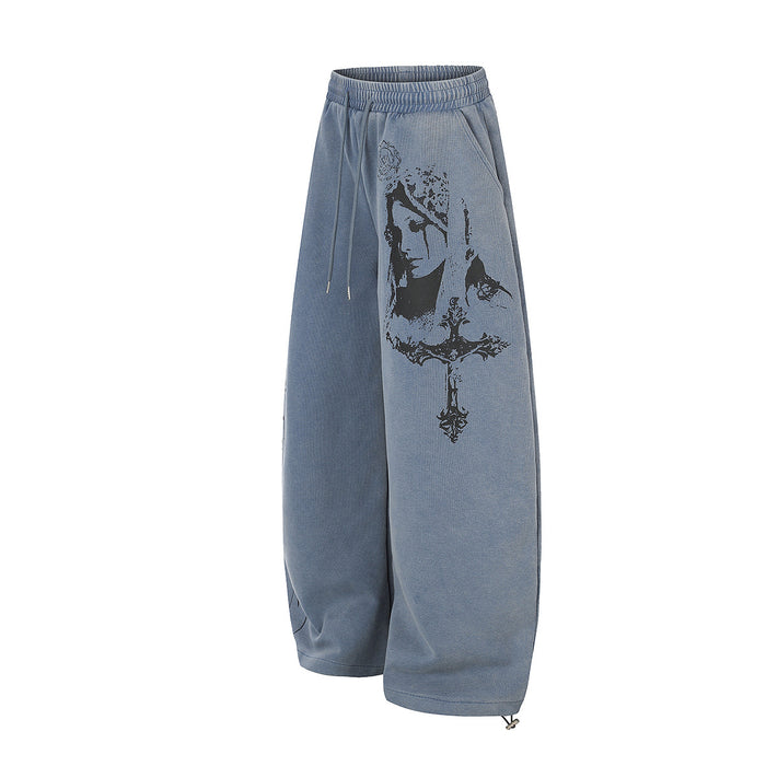 Angled view of washed blue sweatpants showing the gothic portrait print on one leg