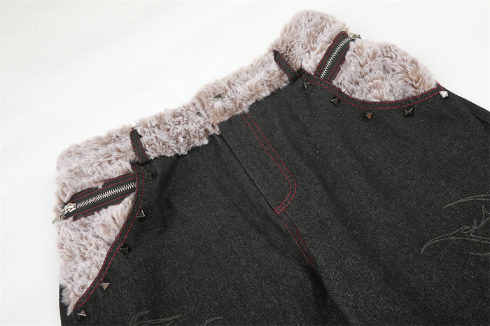 Close-up of the jeans front waist showing faux fur trim, a zippered pocket, red stitching and pyramid rivets