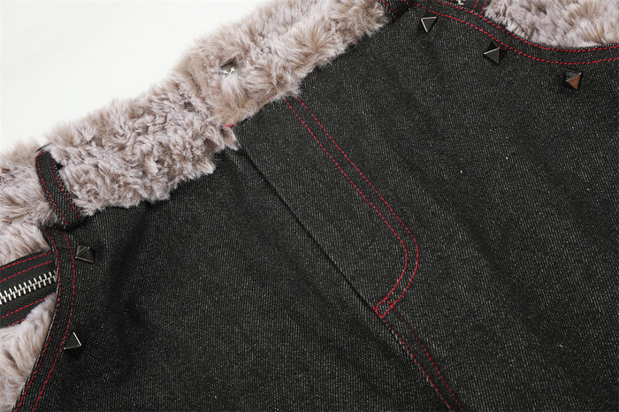 Close-up of a black jeans front pocket with red stitching, faux fur waistband trim and pyramid rivet accents