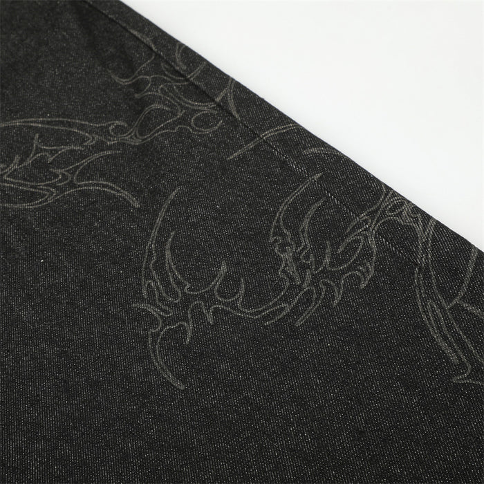 Close-up of subtle curving tonal embroidery on the black denim leg