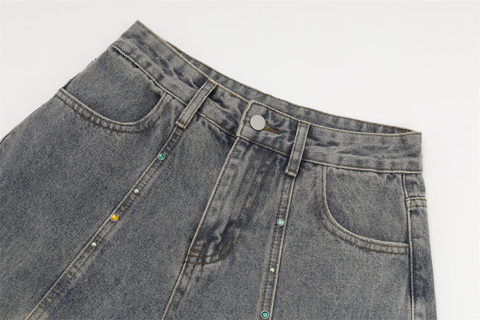 Close-up of the washed gray jeans waistband, front pockets, button, belt loops, and colorful rhinestone seam detail