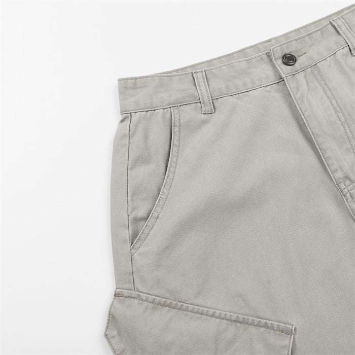 Close-up of light gray cargo pants showing a curved front pocket, belt loop, waistband, and cargo pocket edge