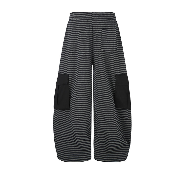 Back view of black and gray striped wide-leg cargo pants with solid black flap pockets