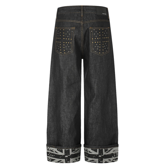 Back view of black wide-leg jeans with two studded patch pockets and gray flag-print rolled cuffs