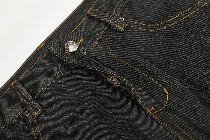 Close-up of the jeans button and partially open fly with contrasting orange stitching and metal hardware