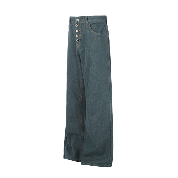 Angled front view of teal green wide-leg jeans showing the button fly, curved pocket, and loose leg shape