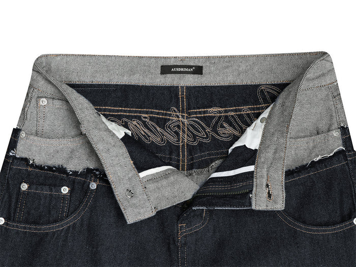 Open waistband detail showing the gray denim lining, inner stitching, zipper, and embroidered pocket interior
