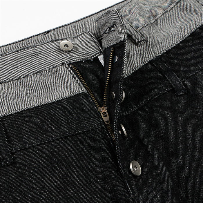 Close-up of the jeans closure showing an open zipper, silver buttons, and contrasting gray waistband