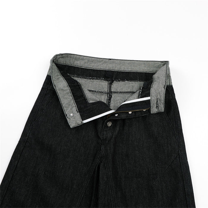 Open waistband view of black jeans showing the gray inner waistband, lining, zipper, and button closure