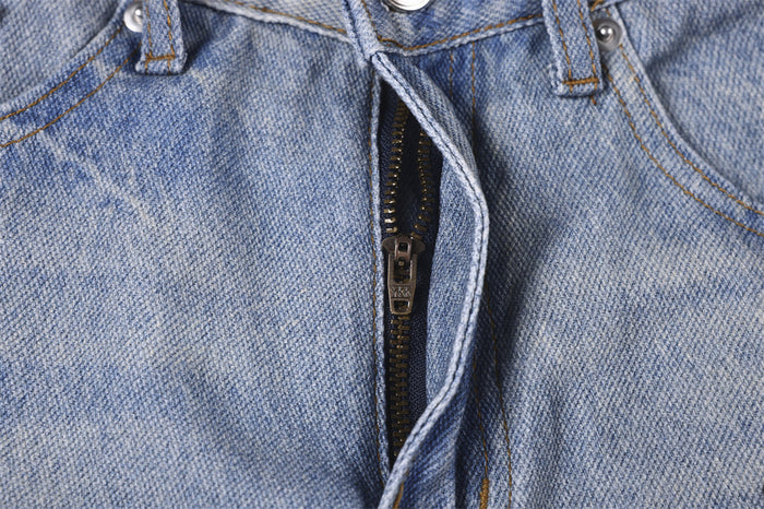 Close-up of the light blue denim fly showing the metal zipper and contrast stitching