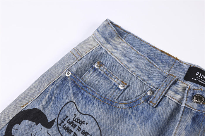 Close-up of the jeans front pocket, belt loops, metal button, and printed cartoon detail
