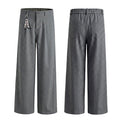 Gray pinstripe wide-leg trousers shown from the front and back with pleats, belt loops and a decorative side charm