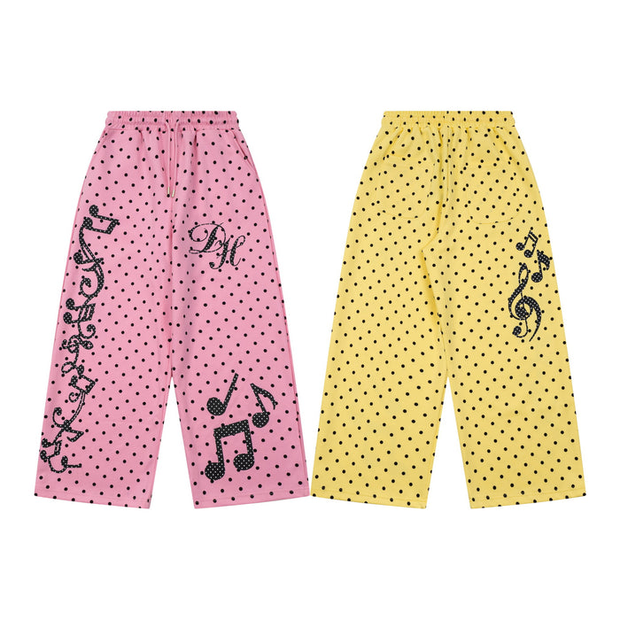 Pink and yellow wide-leg polka dot sweatpants shown together with black musical note and treble clef graphics