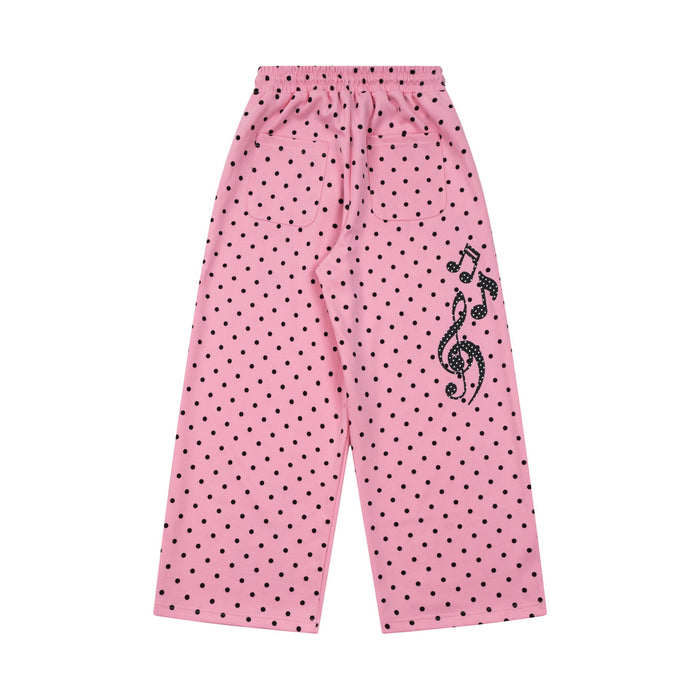 Back view of pink wide-leg polka dot sweatpants with a black treble clef and musical notes